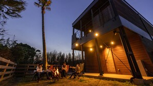 A modern two-story building with a balcony and a fire pit area. - THE Retreat (Iizuka)