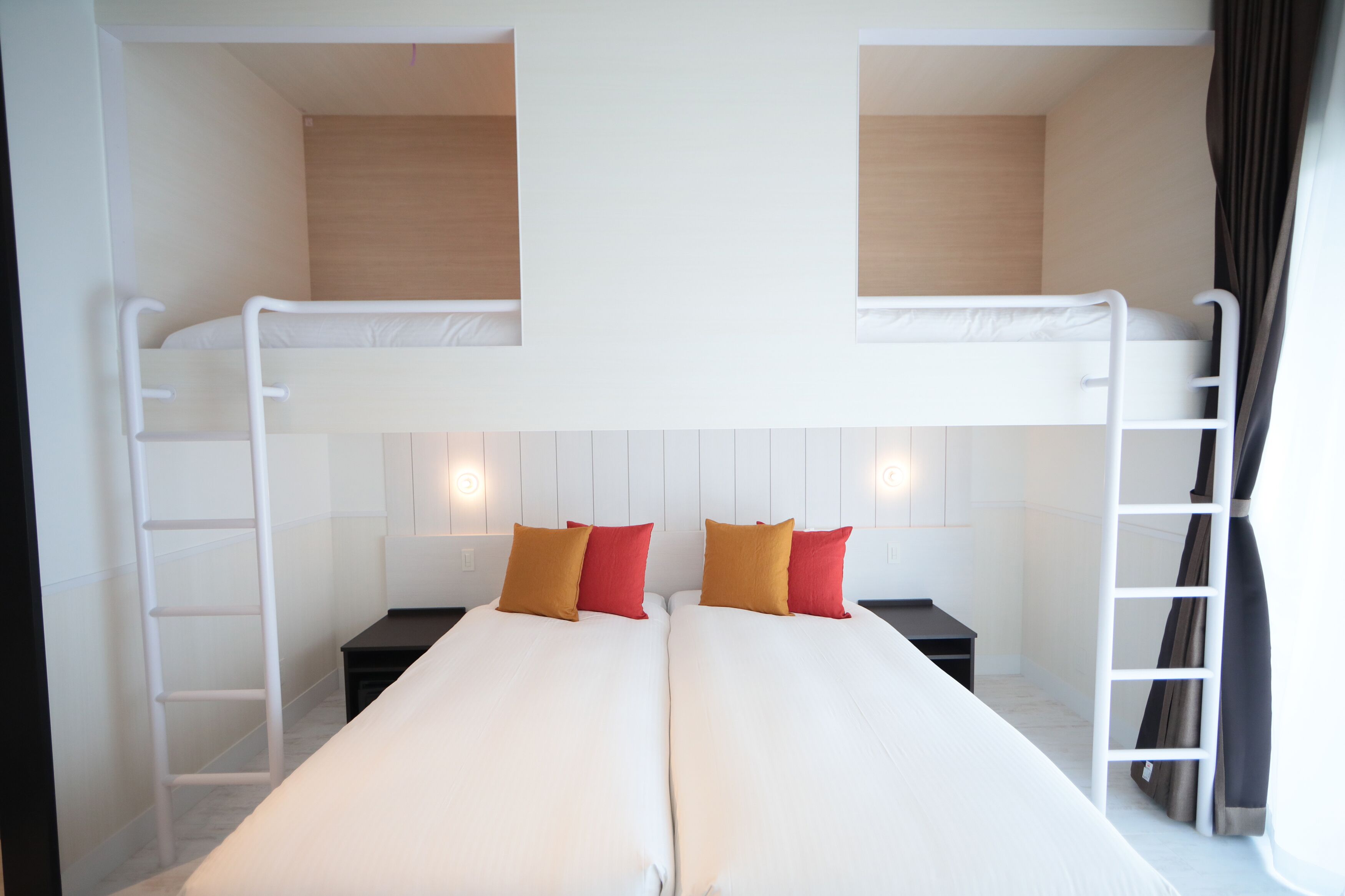 Habitación con literas, dos camas, una escalera y una mesita de noche.