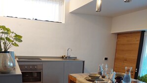 Eine moderne Küche mit einem Holzespeisetisch, einem Einbauofen und einem Fenster mit Vorhängen.