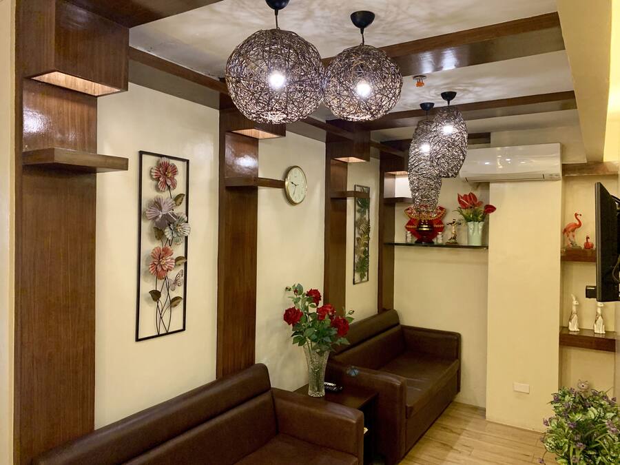 Un saló modern amb revestiment de fusta, un sofà de cuir marró, un rellotge i obra decorativa a la paret.