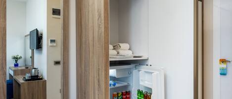 Una cocina moderna con refrigerador empotrado, encimera de madera y un pequeño comedor con banco.