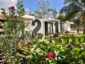 Un edifici modern amb un gran rètol que diu '21', seients a l'exterior i vegetació exuberanta.