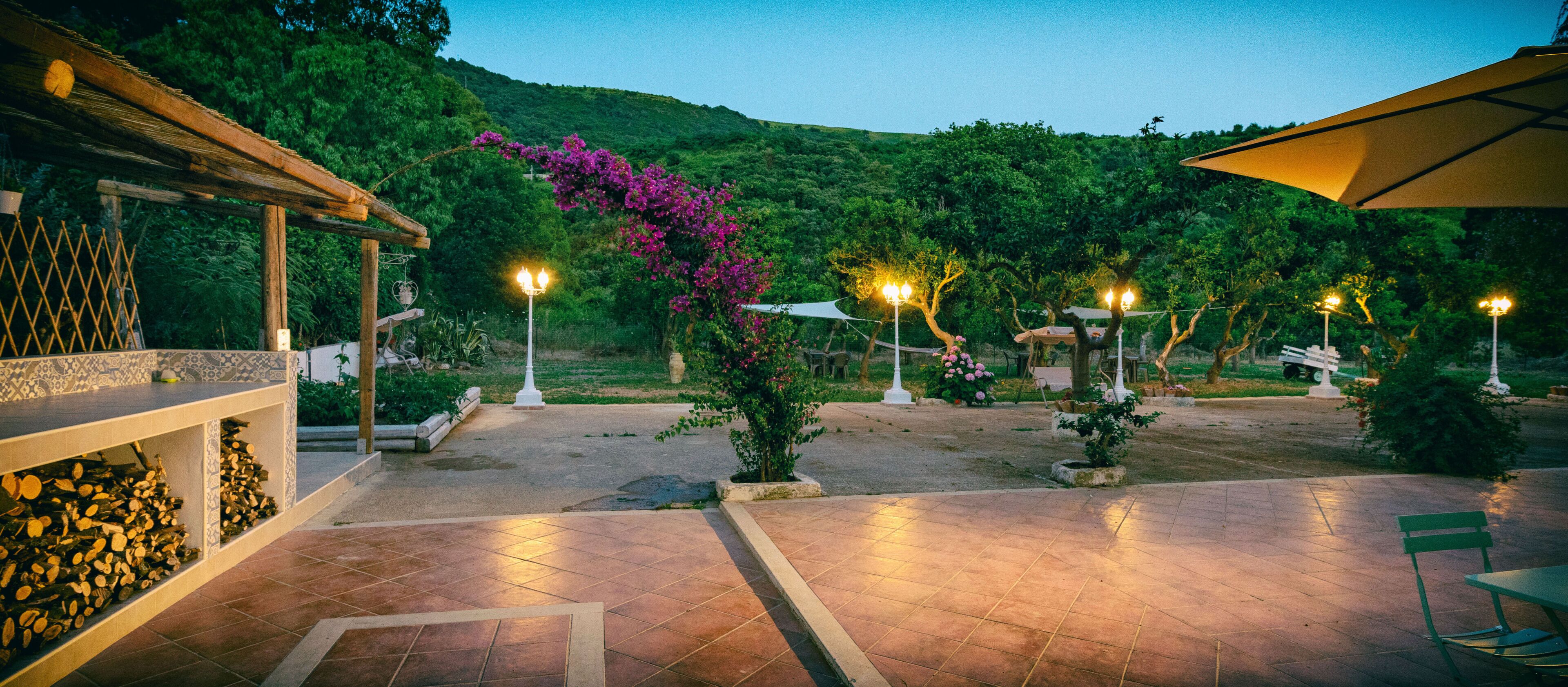 Un espace extérieur aménagé en terrasse, doté d’un sol carrelé, d’une pergola et d’un coin salon avec une table et des chaises.