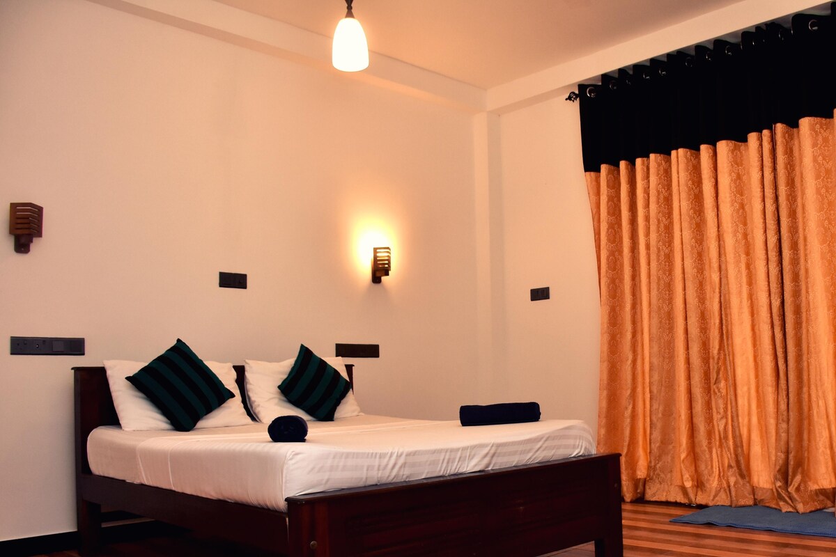 Quarto com cama de madeira, roupa de cama branca e tapete estampado.
