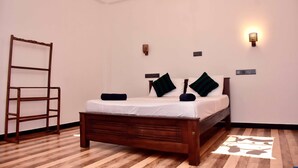 A bedroom with a wooden bed, a ladder, and a wall-mounted light fixture. - Hotel Aram (Unawatuna)