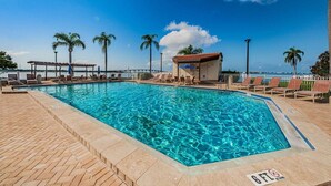 Una piscina rettangolare con acqua cristallina, circondata da lettini e un piccolo padiglione.