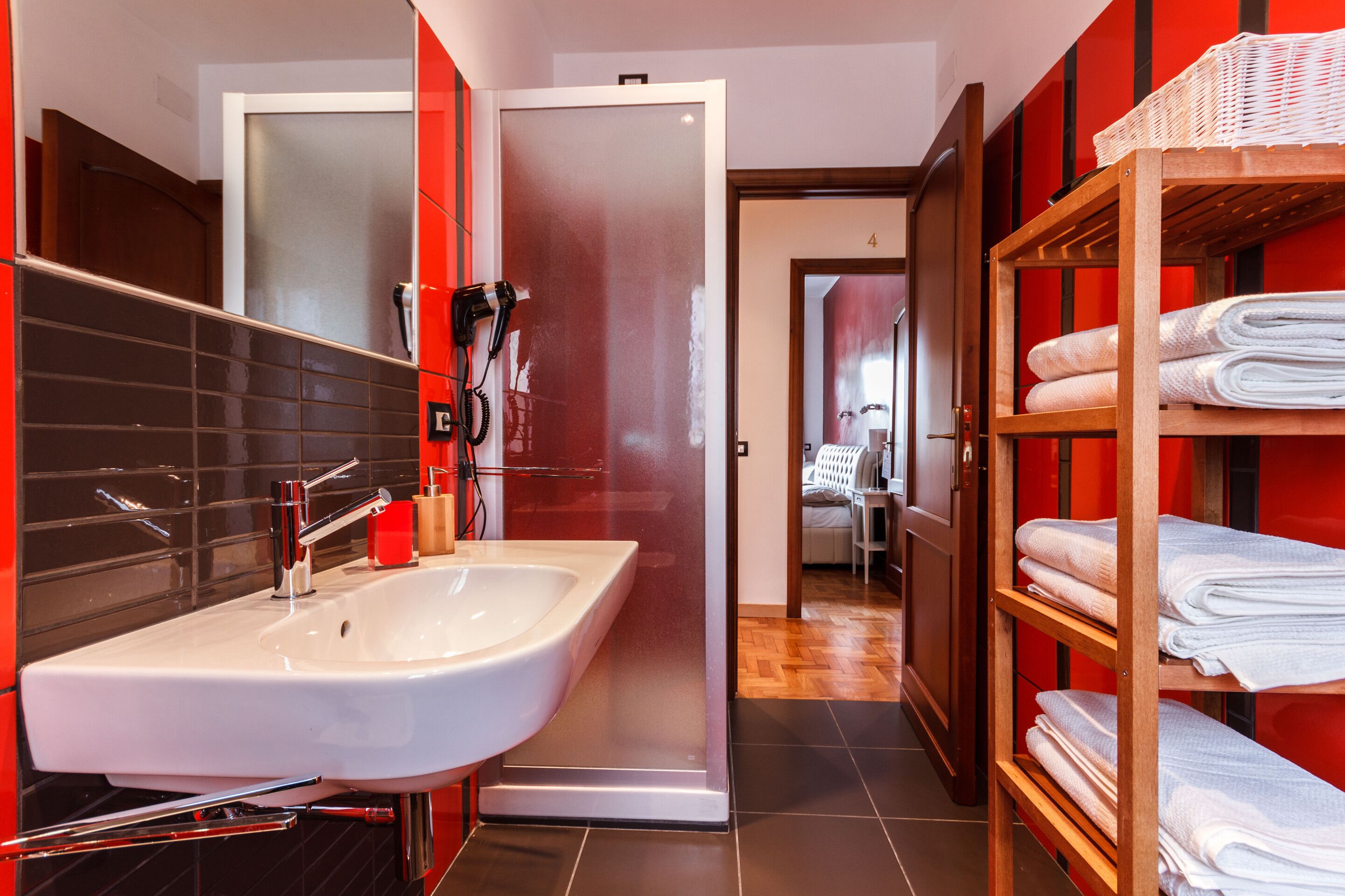 Une salle de bain moderne avec un grand lavabo, un sèche-cheveux et un porte-serviettes.