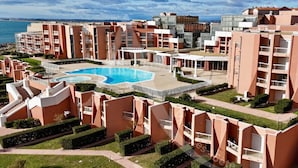 Un complejo residencial con varios edificios de apartamentos, una piscina central y zonas verdes cuidadas.