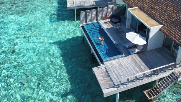 An overwater bungalows with infinity pools, clear turquoise water, and a view of the ocean. - Radisson Blu Resort Maldives with 50 percent off on Sea Plane round trip 03 nights & above (Huruelhi Island)