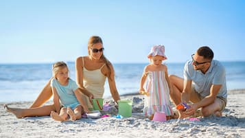 En privat strand, hvidt sand, liggestole, parasoller