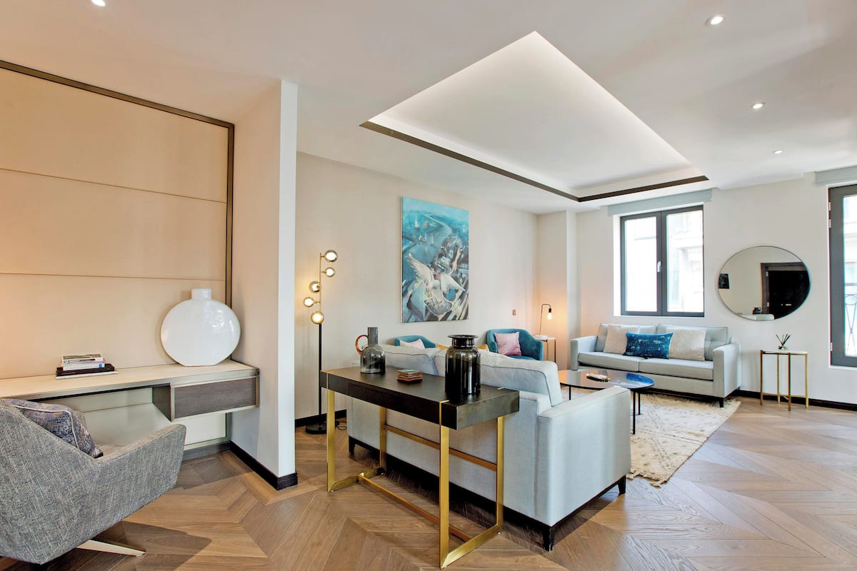 Ein modernes Wohnzimmer mit einer Couch, einem Couchtisch und einem Schreibtisch mit Lampe.