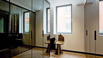 Enjoy a spacious room with a glass partition offering a view, paired with a cabinet and comfortable hand-shaped stools.