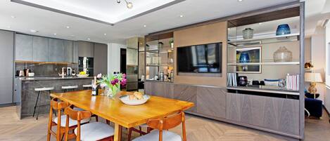 A modern kitchen with a wooden dining table, built-in appliances, and a large island.