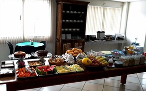 Ein reichhaltiges Frühstücksbuffet mit verschiedenen Früchten, Gebäck und Getränken.