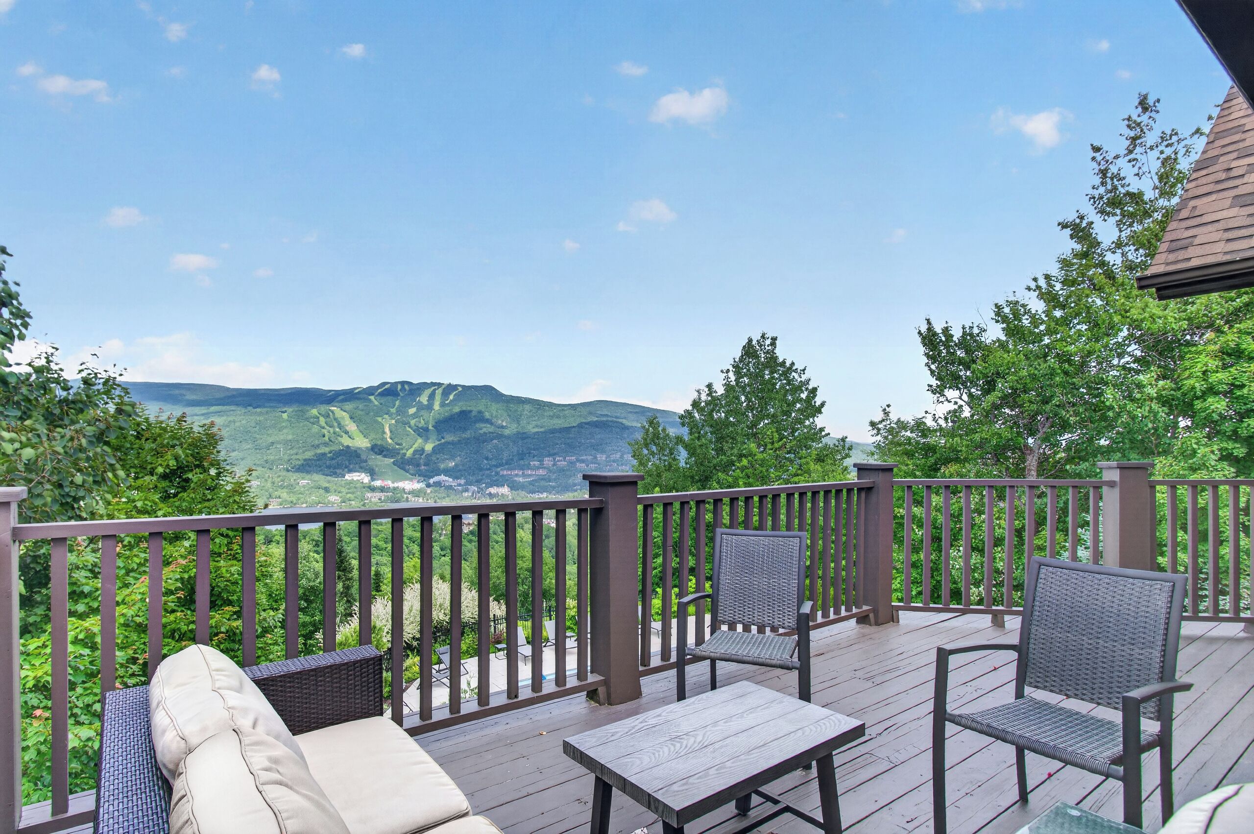 Une terrasse dotée de mobilier d’extérieur, offrant une vue sur un paysage montagneux et s’ouvrant sur un ciel dégagé.