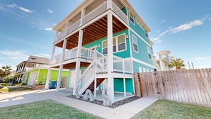 A two-story house with a balcony and a wooden deck. - Luxury Home Detached Suite, Private Pool, Located Near Beach (Port Aransas)