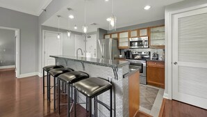 A modern kitchen with a central island, stainless steel appliances, and pendant lighting. - Escape to Paradise: Luxe 2-Bedroom Retreat (Henderson)