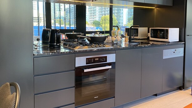 A modern kitchen with a built-in oven, microwave, and coffee maker. - New luxury 3bedroom townhouse cityview (South Melbourne)