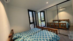A bedroom with two beds, a large mirror, and a sliding door to a balcony. - New luxury 3bedroom townhouse cityview (South Melbourne)