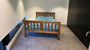A bedroom with a bed, a wardrobe, and a built-in air conditioning unit. - New luxury 3bedroom townhouse cityview (South Melbourne)