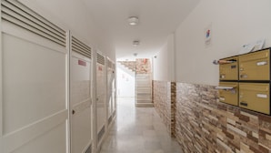 Un pasillo con taquillas, una escalera y un revestimiento de baldosas.