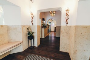 A hallway with a bench, a potted plant, and a staircase leading to another level. - Berial (Düsseldorf)