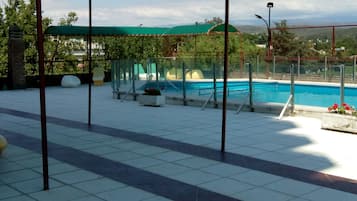 Una piscina al aire libre, una piscina climatizada