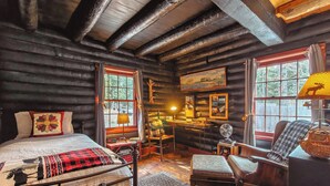 A log cabin room with a bed, desk, chair, and a large window. - 40 Acre Forested Privacy w/ Deeded Beach Access Near Acadia Schoodic (Prospect Harbor)