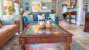 A living room with a sofa, coffee table, and a staircase. - Barrier Dunes Cottage  Steps from beach/pool/tennis. 2/2 plus loft - SPECIALS!!! (Port St Joe)