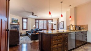 Une cuisine moderne dotée d’un grand îlot central, de meubles en bois et de luminaires suspendus.