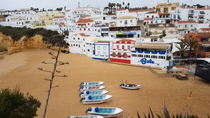 Eine Küstenstadt mit weißen Häusern, einem Sandstrand und mehreren vor Anker liegenden Booten.
