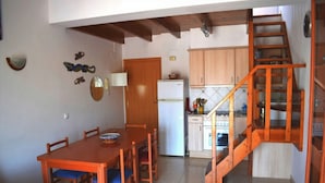 A kitchen with wooden cabinets, a white refrigerator, and a wooden staircase. - 238-Apartment with terrace and view on canal (Empuriabrava)