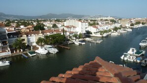 A coastal town with buildings along a marina, boats docked, and a clear sky. - 238-Apartment with terrace and view on canal (Empuriabrava)