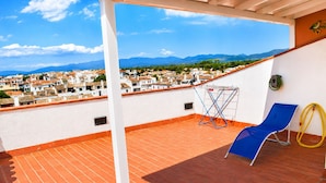 A rooftop terrace with a blue lounge chair, a drying rack, and a hose. - 238-Apartment with terrace and view on canal (Empuriabrava)