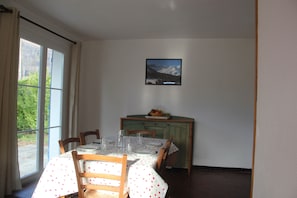 A dining area with a table set for four, chairs, a cabinet, and a framed picture on the wall. - A detached house in the heart of the Pyrenees (Aucun)