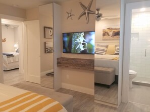 Relax in a serene bedroom with a large bed, television, and starfish decoration.
