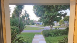 Une rue résidentielle avec un trottoir menant  à une maison.