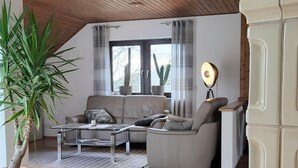 A modern living room with a sofa, coffee table, and potted plants.