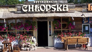 A rustic restaurant with a thatched roof, wooden signage, and vibrant flower arrangements. - 3 room apartment with terrace, 450m from the sandy beach, close to the nature park, garden (Rowy)