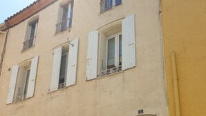 A two-story building with a beige facade, white shutters, and a white door with a glass window. - DUPLEX OF 110 M2 NEAR QUAY AND SHOPS, 8 persons (Port-Vendres)