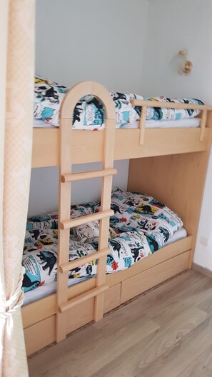 Cozy sleeping quarters feature a bunk bed with a ladder and a fun, patterned bedspread.