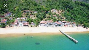 An aerial view of a coastal area with houses, a beach, and a pier. - Camping do Bené (Angra dos Reis)