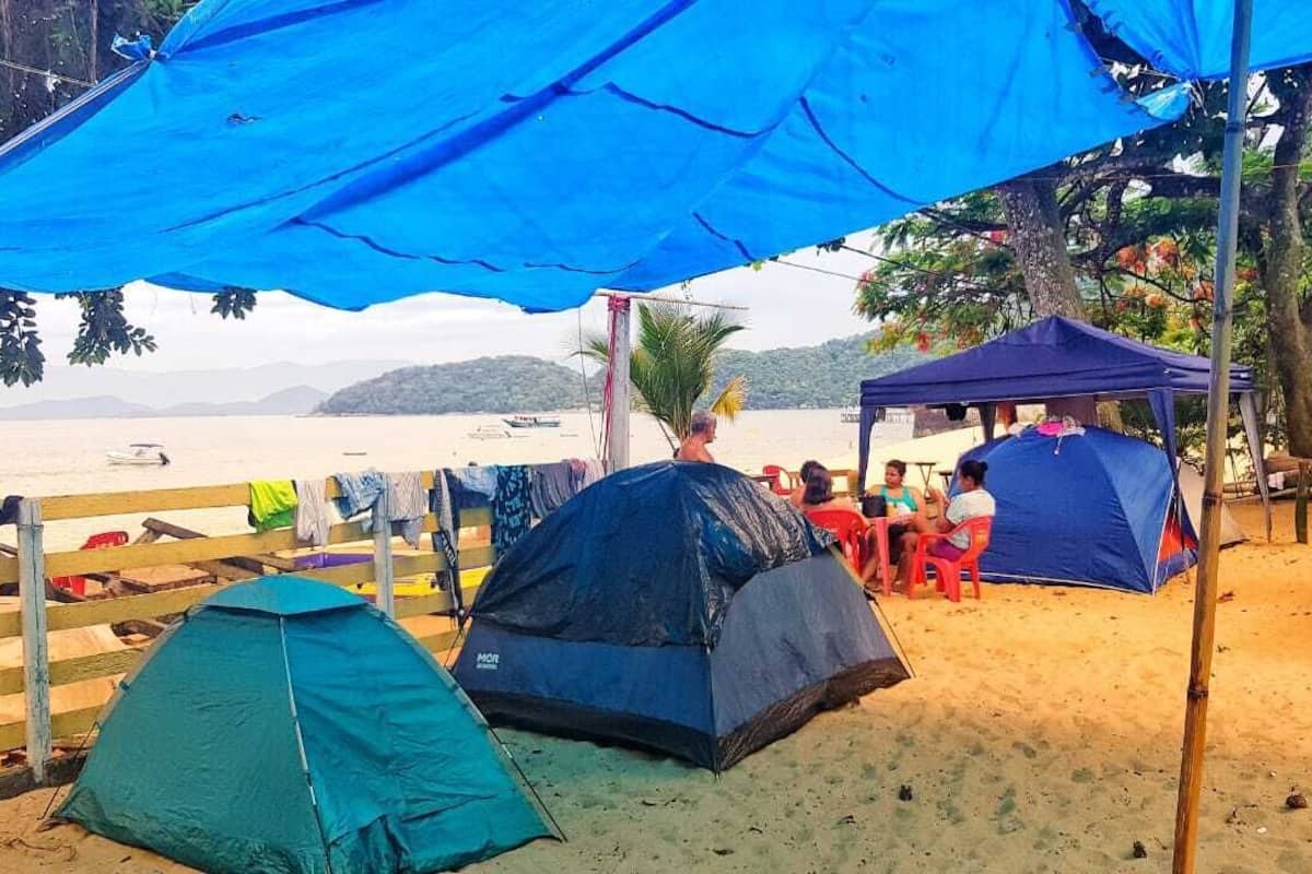 Una playa con tiendas de campaña y una valla de madera.