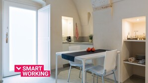 Une cuisine moderne avec des meubles blancs, un plan de travail et un porte-ustensiles suspendu.