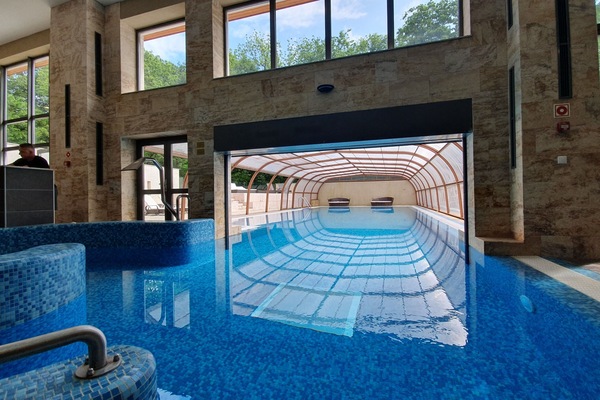 Een binnenzwembad, een buitenzwembad en parasols bij het zwembad