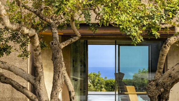 A modern building with large glass windows and a view of the sea. - Villa Nemini Teneri - Luxury Villa with pool (Sampieri)