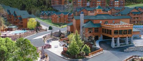 A lodge with multiple wooden buildings, a swimming pool, and a central courtyard.