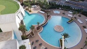 A large outdoor swimming pool with multiple sections and surrounding lounge areas. -  Fantastic Gulfview condo 1 br/2 ba , bunk , sleep 6 (Panama City Beach)