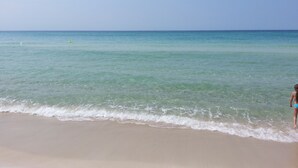 A beach with clear turquoise water and a person standing on the sand. -  Fantastic Gulfview condo 1 br/2 ba , bunk , sleep 6 (Panama City Beach)