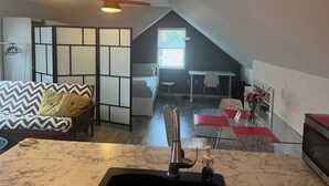 Une chambre de style loft moderne, comprenant un lit, un bureau et un coin cuisine.